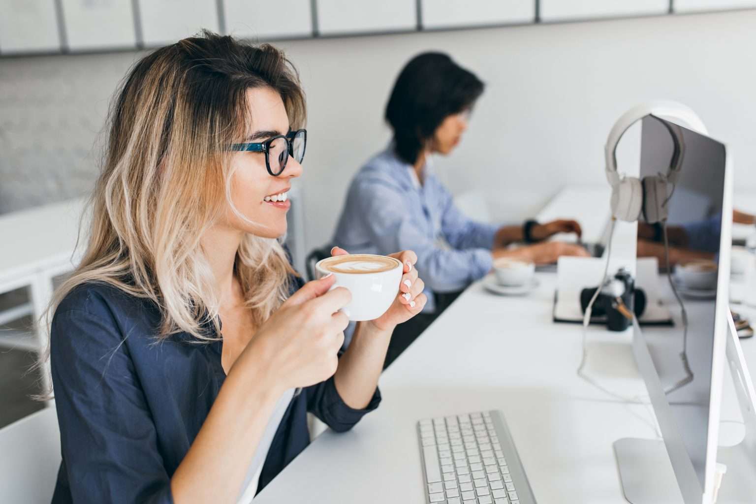 female-it-specialist-looking-computer-screen-while-drinking-coffee-with-pleasure-1536x1024